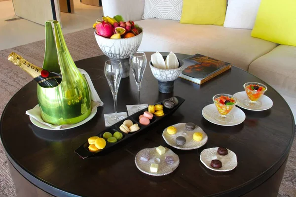 Milan, Italy- 29 Nisan 2014: Çeşitli tatlılar, çikolatalar ve bir şişe şampanyayla süslü koyu ahşap masa seti