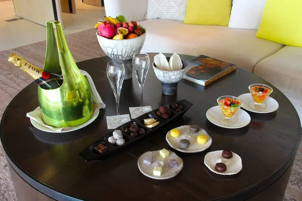 Milan, Italy- 29 Nisan 2014: Çeşitli tatlılar, çikolatalar ve bir şişe şampanyayla süslü koyu ahşap masa seti