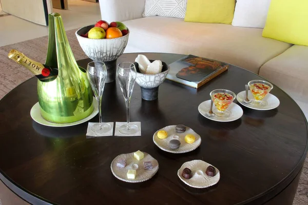 Milan, Italy- 29 Nisan 2014: Çeşitli tatlılar, çikolatalar ve bir şişe şampanyayla süslü koyu ahşap masa seti