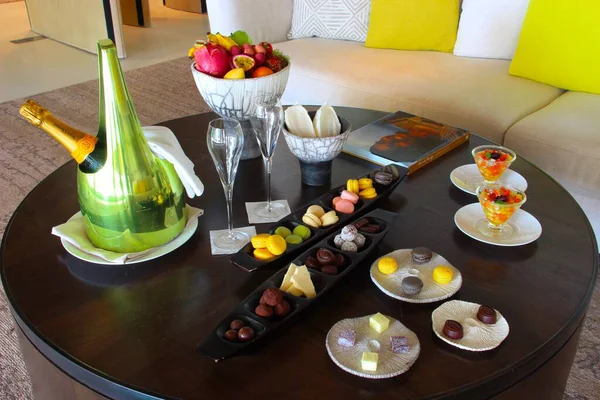 Milan, Italy- 29 Nisan 2014: Çeşitli tatlılar, çikolatalar ve bir şişe şampanyayla süslü koyu ahşap masa seti