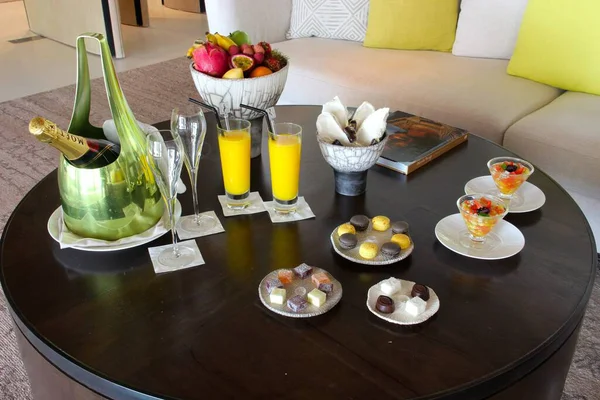 Milan, Italy- 29 Nisan 2014: Çeşitli tatlılar, çikolatalar ve bir şişe şampanyayla süslü koyu ahşap masa seti