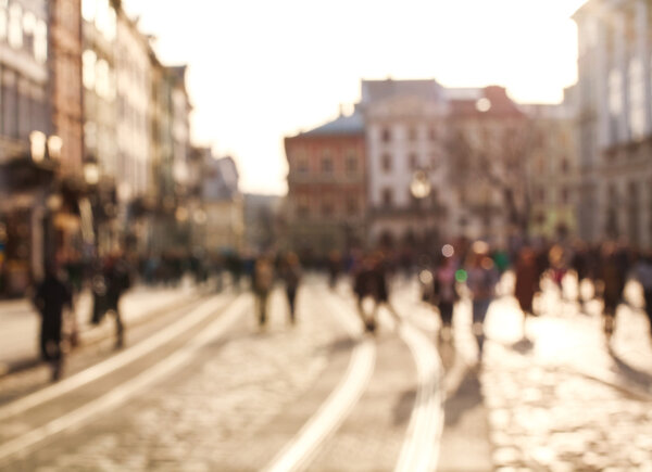 Blurred background people in town square of old city at sunset 