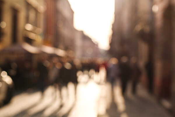 Blurred background people in town square of old city at sunset 