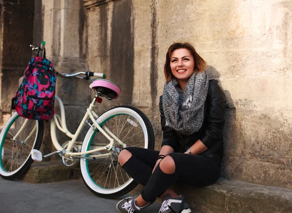 Chica feliz con bicicleta vintage en el fondo de la ciudad vieja — Foto de Stock