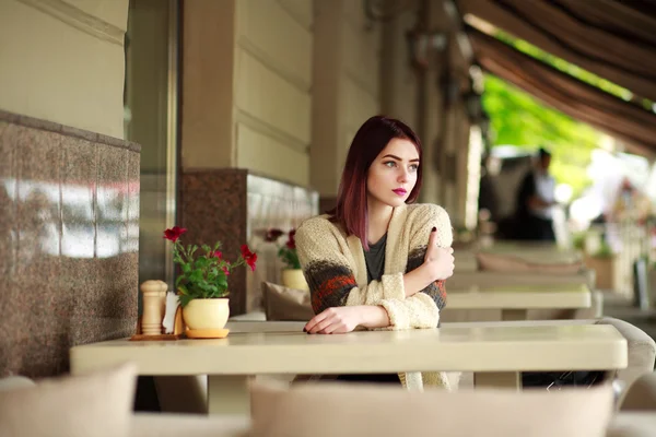 Nachdenkliche einsame Frau in einem Café auf einem Sommergelände — Stockfoto