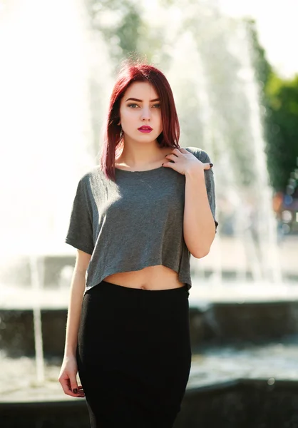 Elegante chica de pelo castaño posando frente a la fuente de la ciudad —  Fotos de Stock