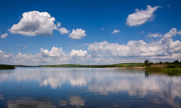 Paisaje pacífico del lago en el pueblo en el fondo del cielo azul — Foto de Stock