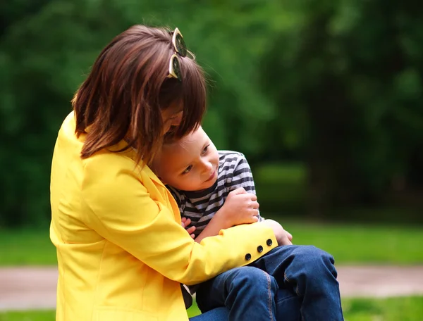 Sad mother and son in summer green park — Stock Photo, Image