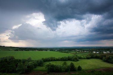 Fırtına bulutları gökyüzü arka plan üzerinde yeşil alanlarda yaz Köyü