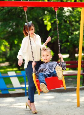Salıncak Bahçesi yaz parkta oynayan çocuk ile anne