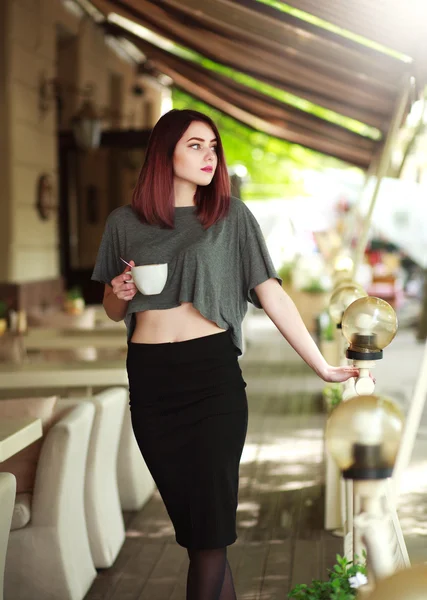 Morena elegante com xícara de café no fundo do café de verão — Fotografia de Stock