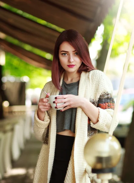Morena elegante com xícara de café no fundo do café de verão — Fotografia de Stock