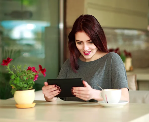 Joyful jovem morena assistindo em tablet no café de verão — Fotografia de Stock