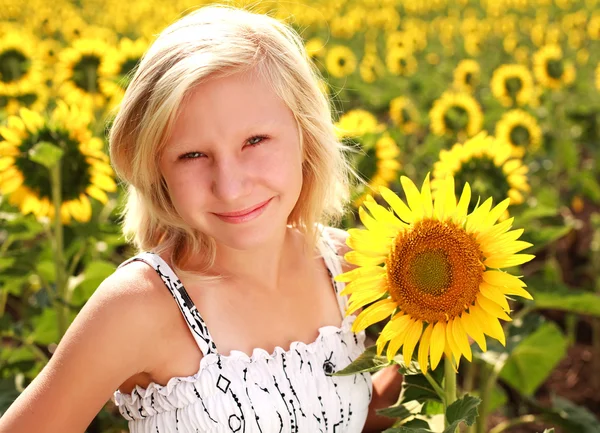 Gelukkig lachend tiener meisje met zonnebloemen in zomer veld — Stockfoto