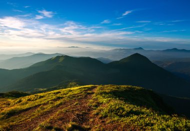 Günbatımı gökyüzü arka plan üzerinde dağın zirvesinde iz