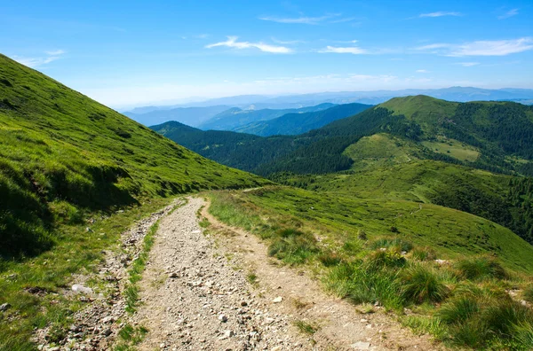 Soil road in mountains on background blue sky in summer — Stock Photo, Image