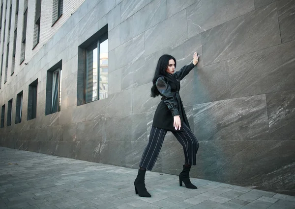 石の壁 近代的な都市建築 流行のスタイルの写真の背景にファッショナブルな黒のカジュアルな服の女の子 — ストック写真