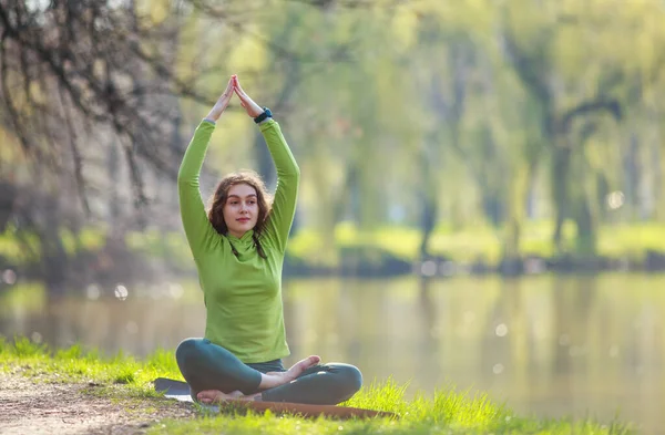 Jonge Vrouw Mediteert Beoefent Yoga Oever Van Rivier Tegen Achtergrond — Stockfoto
