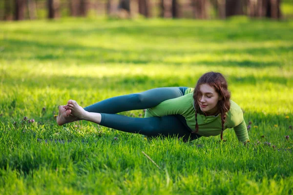 緑の芝生の上の公園で運動スポーツの女の子は 純粋な自然の中で体を伸ばしフィットネス演習を行い 健康的なライフスタイル — ストック写真