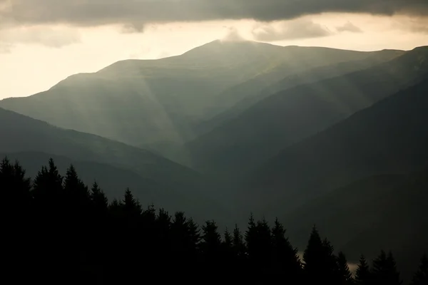 Berglandschap, de stralen van de zon door de storm wolken — Stockfoto