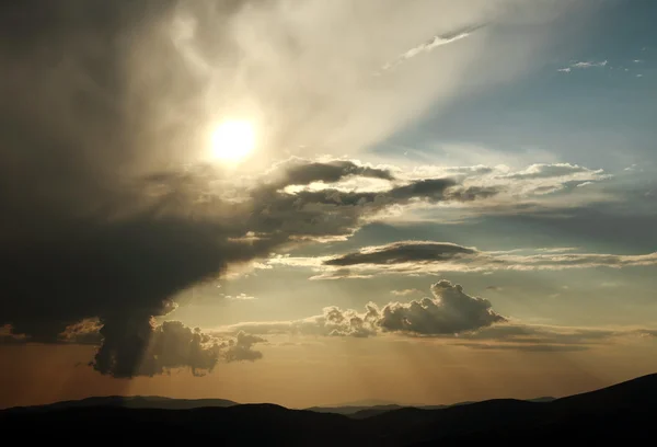 Dağlarda günbatımında güneş ışınlarının gökyüzünde — Stok fotoğraf
