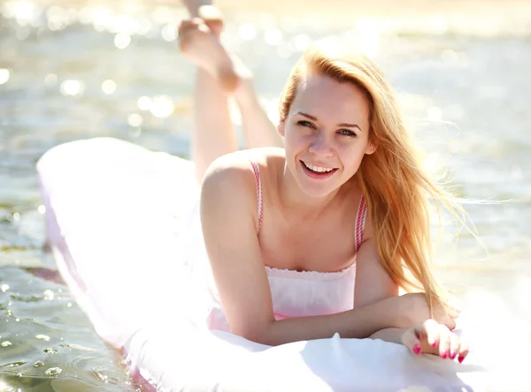 Mulher sorridente feliz encontra-se em uma cama de água, dia ensolarado do verão — Fotografia de Stock