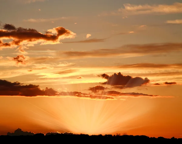 Kleurrijke hemel met wolken in de stralen van de ondergaande zon, schoonheid — Stockfoto