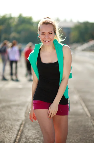 Jeune femme sportive le matin avec casque sur tapis roulant — Photo