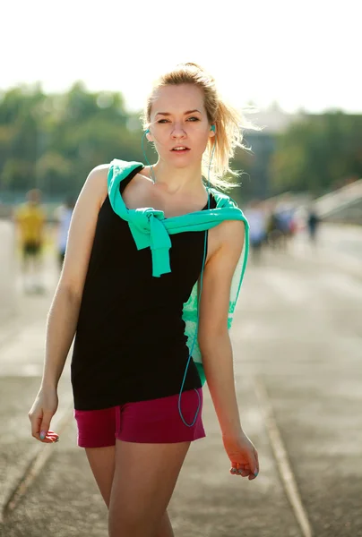 Jeune femme sportive le matin avec casque sur tapis roulant — Photo