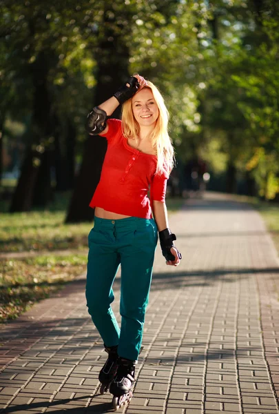 Glad ung tjej njuter rullskridskoåkning i park — Stockfoto