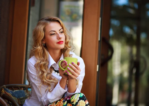 Zamyšlená žena sedí s šálkem kávy a má odpočinek — Stock fotografie