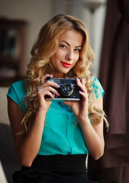 Mulher fotógrafa tirar fotos com câmera de filme retro dentro de casa — Fotografia de Stock