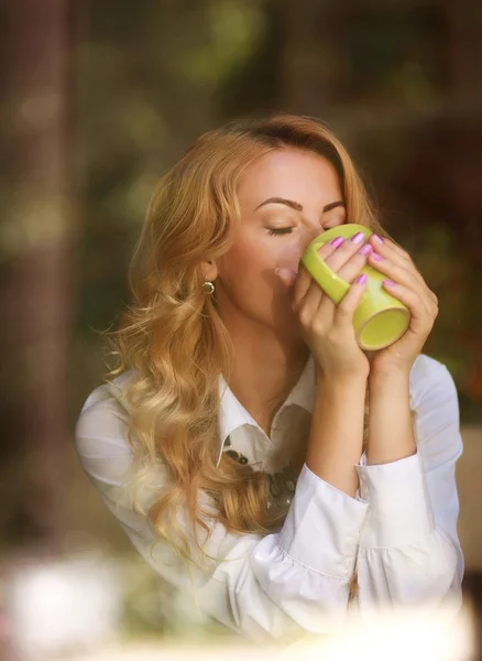 Woman drinking coffee indoors, enjoying the aroma of beverage — Stock Photo, Image