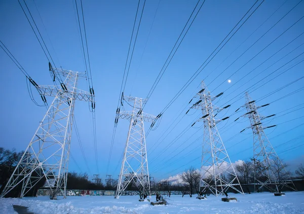 Elstolpar och högspänningstorn på vintern — Stockfoto