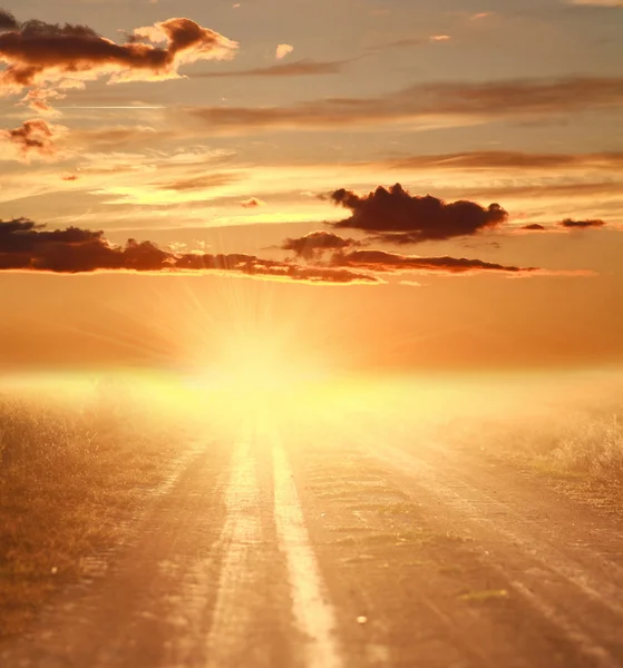 Kleurrijke sunset over landweg op dramatische hemel — Stockfoto