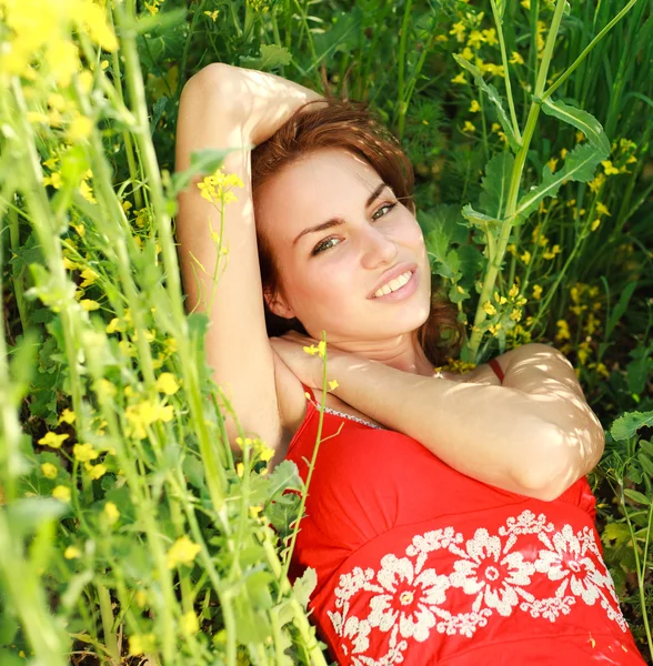Mujer joven relajándose en un hermoso prado verde — Foto de Stock