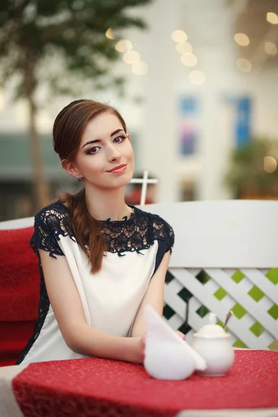 Niedliche lächelnde Frau sitzt drinnen im Café-Restaurant — Stockfoto