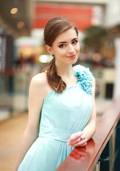 Krásná mladá žena v dlouhé modré šaty, v interiéru — Stock fotografie