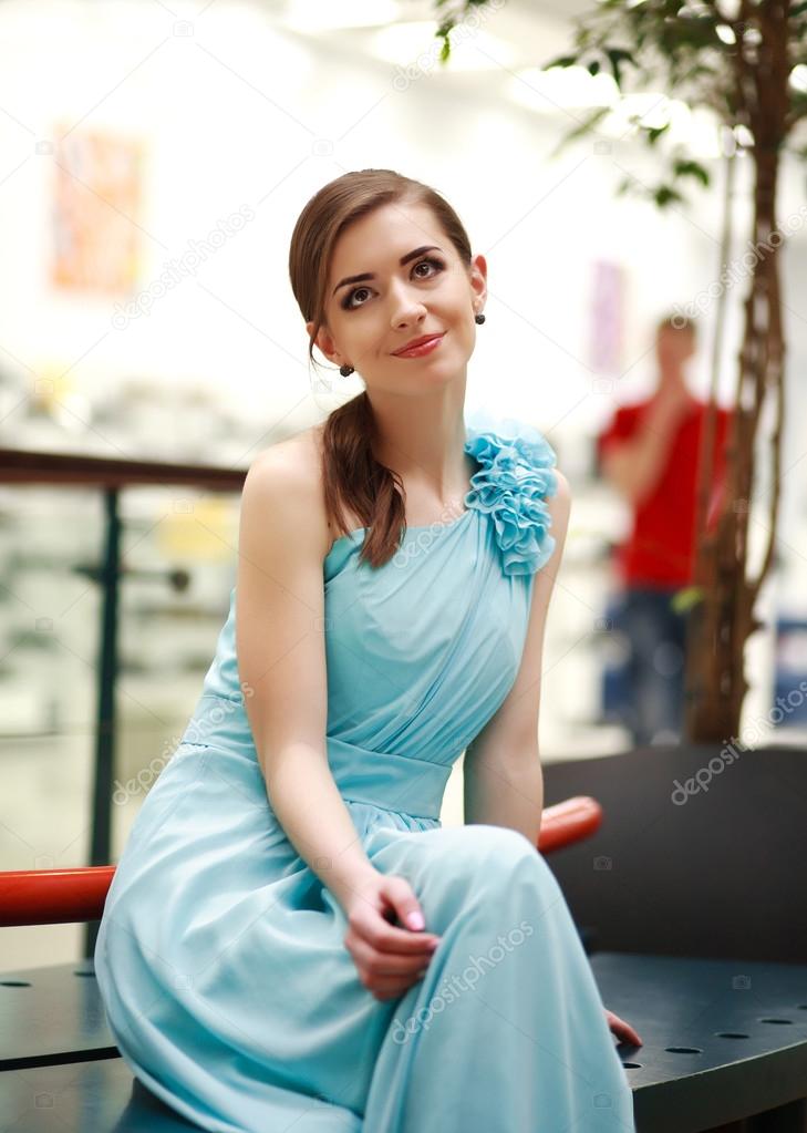 Beautiful young woman in a long blue dress in anticipation