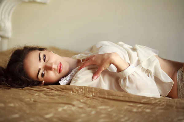 Sensual young woman thoughtfully lying on the bed at home — Stock Photo, Image