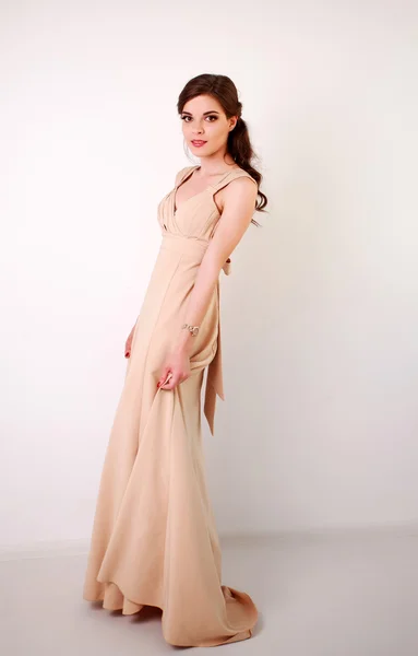 Mode junge brünette Frau in pastellfarbenem langen Kleid im Studio — Stockfoto