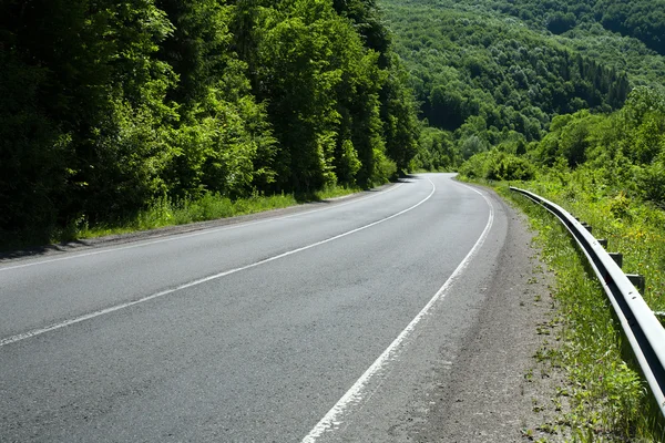 Estrada asfáltica vazia nas montanhas arborizadas — Fotografia de Stock