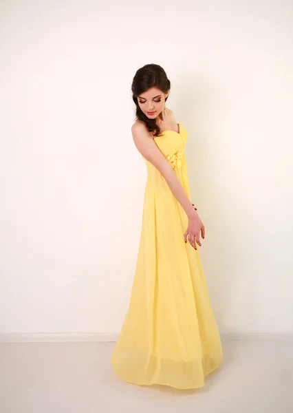 Mujer joven de moda en vestido largo amarillo, estudio en blanco —  Fotos de Stock