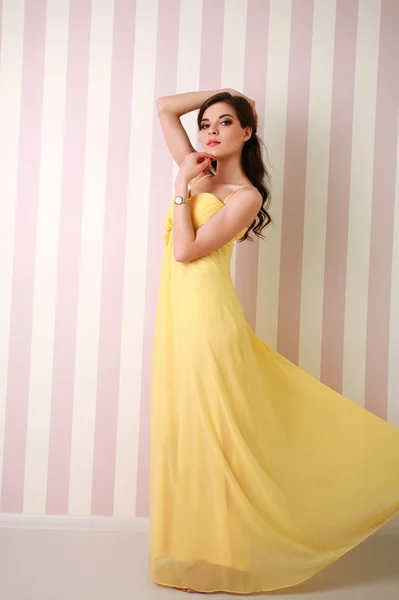 Mode junge Frau im langen gelben Kleid, Atelier — Stockfoto