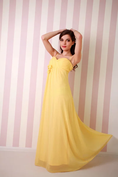 De jonge vrouw mode in lang gele jurk, studio — Stockfoto