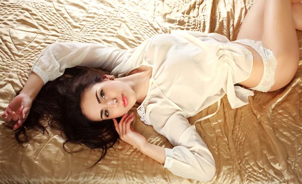 Young sensual woman in lingerie lying on bed — Stock Photo, Image