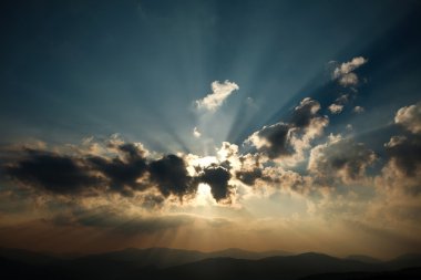 Dağlarda bir bulutlu gökyüzü üzerinde gündoğumu parlayan