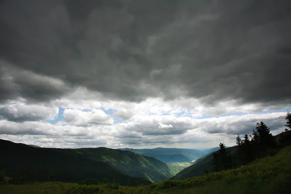 Paisaje montañas verdes sobre un fondo de nubes de tormenta —  Fotos de Stock