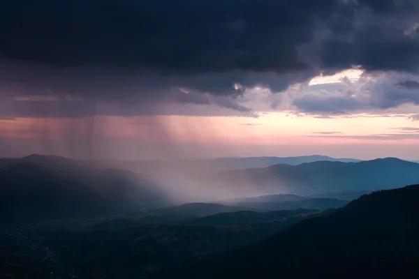 Landscape of rain clouds over the valley between the mountains