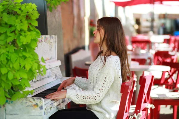 Mädchen spielt in Straßencafé auf einem alten Klavier — Stockfoto